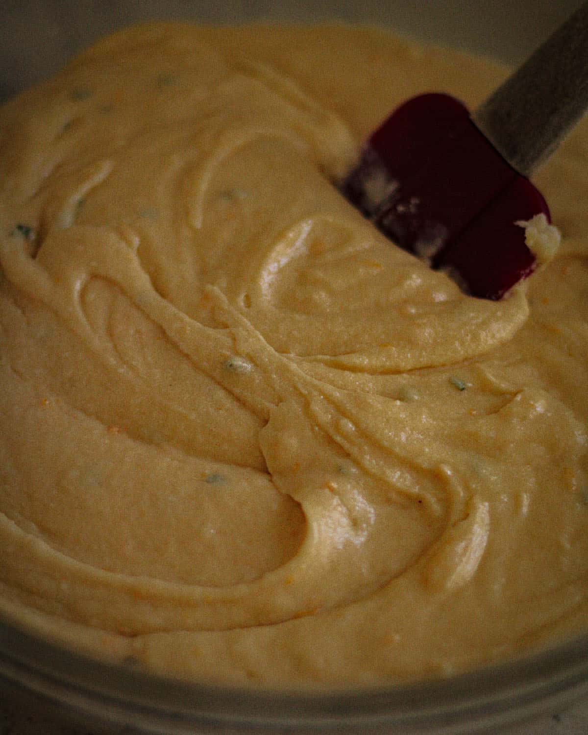 Cake batter being stirred with a spatula. 