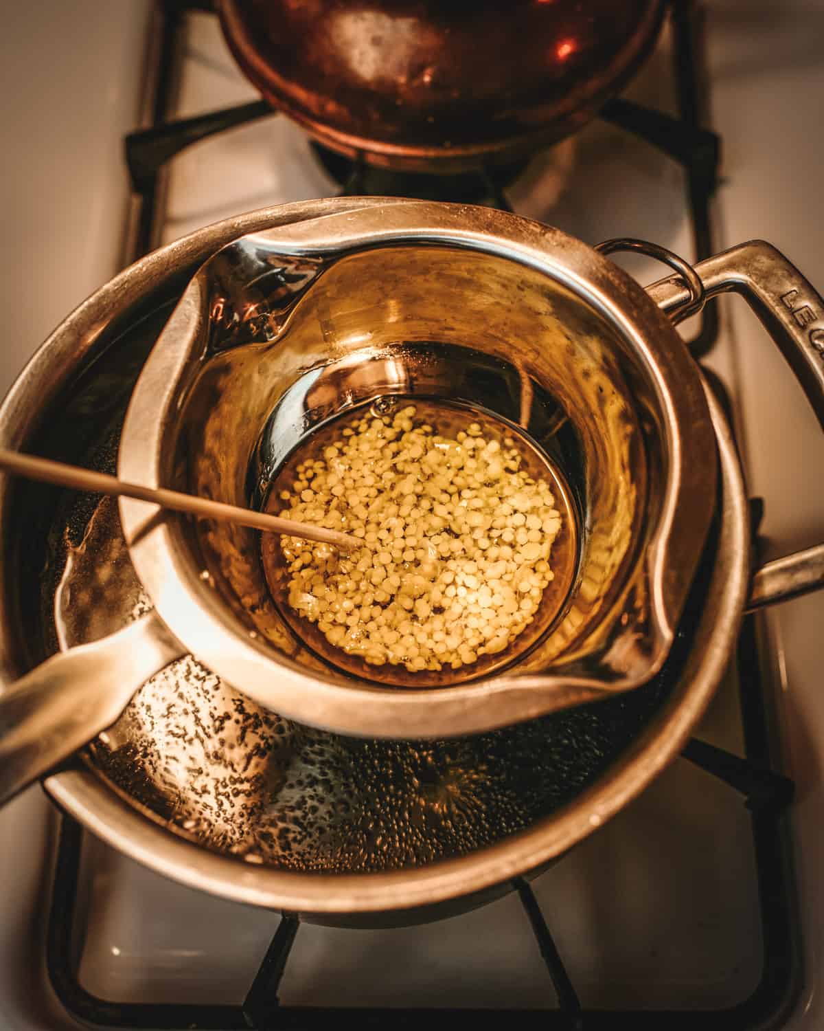 Melting beeswax in a double boiler pot. 