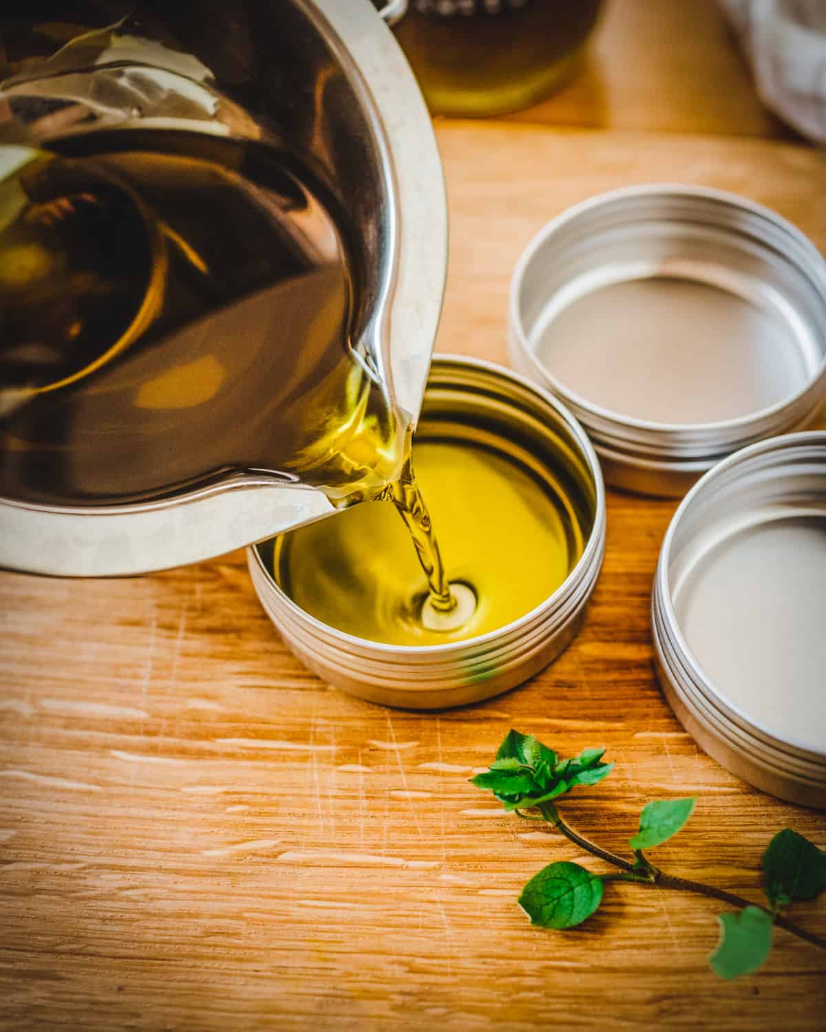 Hot chickweed salve being poured into tin containers to harden. 