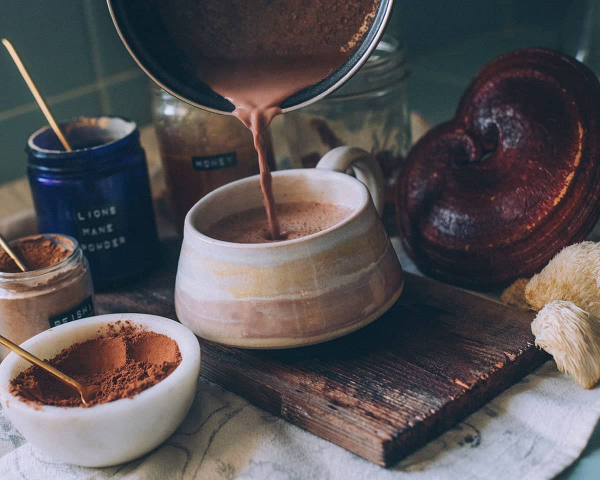 pouring mushroom hot chocolate from a pot to a mug