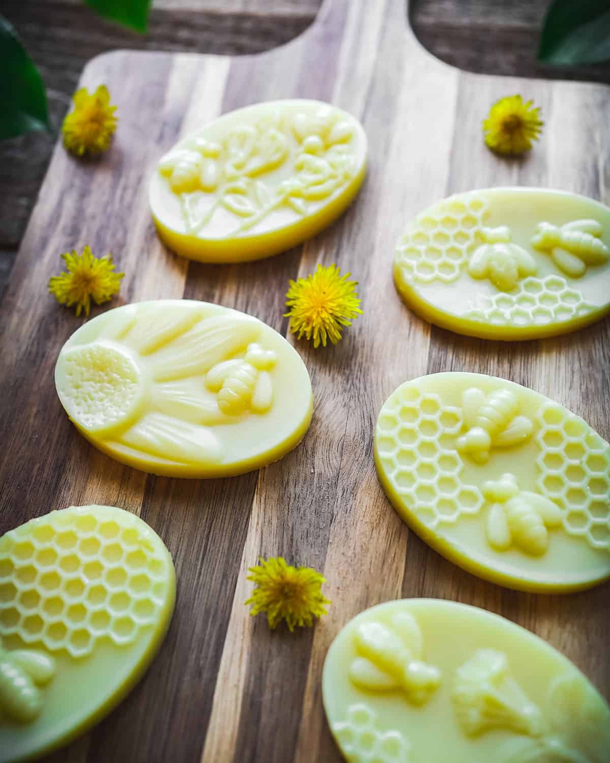 Finished dandelion lotion bars, close up on a wooden cutting board. 