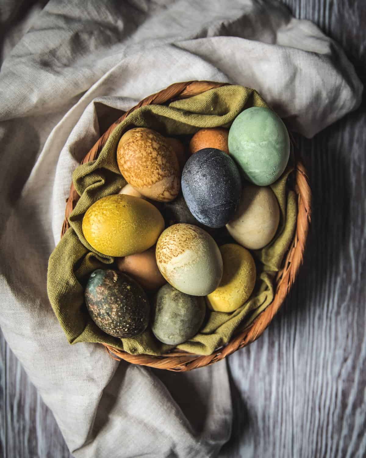 a basket of naturally dyed easter eggs with herbal tea