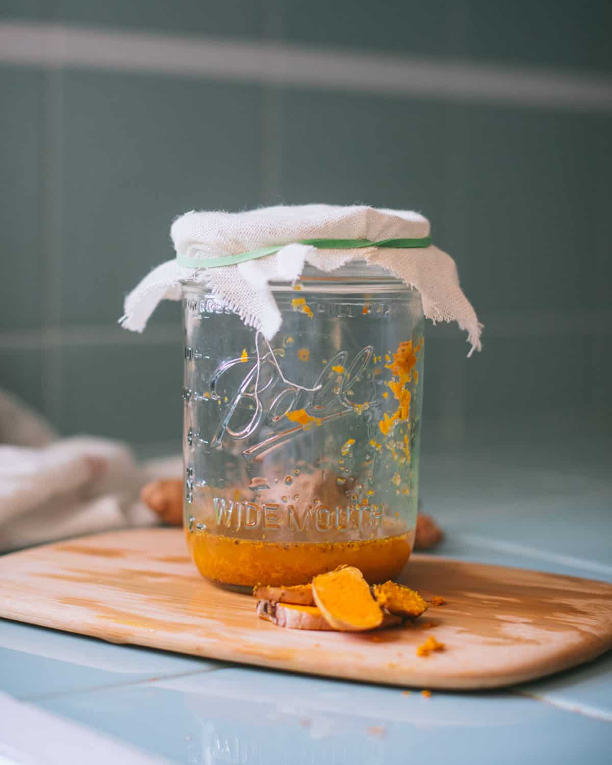 a jar of turmeric bug covered with cheesecloth on day one