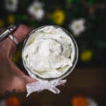 Top view of whipped body butter in a jar with a white lace bow.