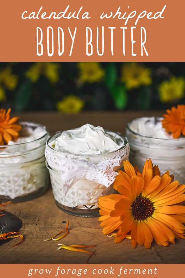 Whipped body butter in small jars surrounded with calendula flowers.