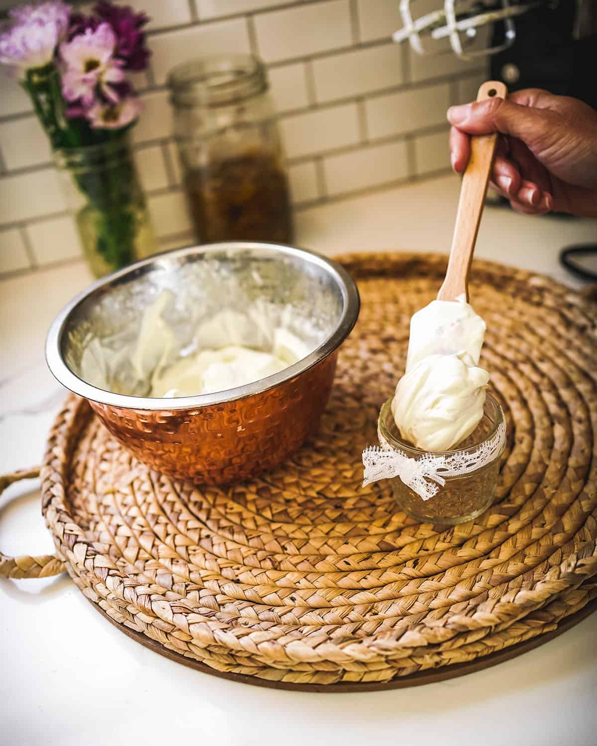 A spatula filling jars with whipped body butter.