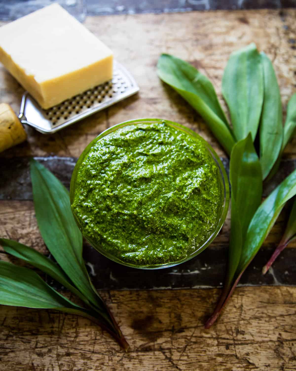 a bowl of ramp pesto on a wooden table 