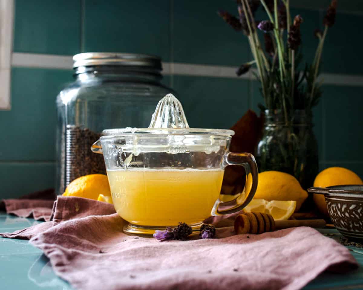 A bowl with a glass juicer on top, filled with freshly squeezed lemon juice. 
