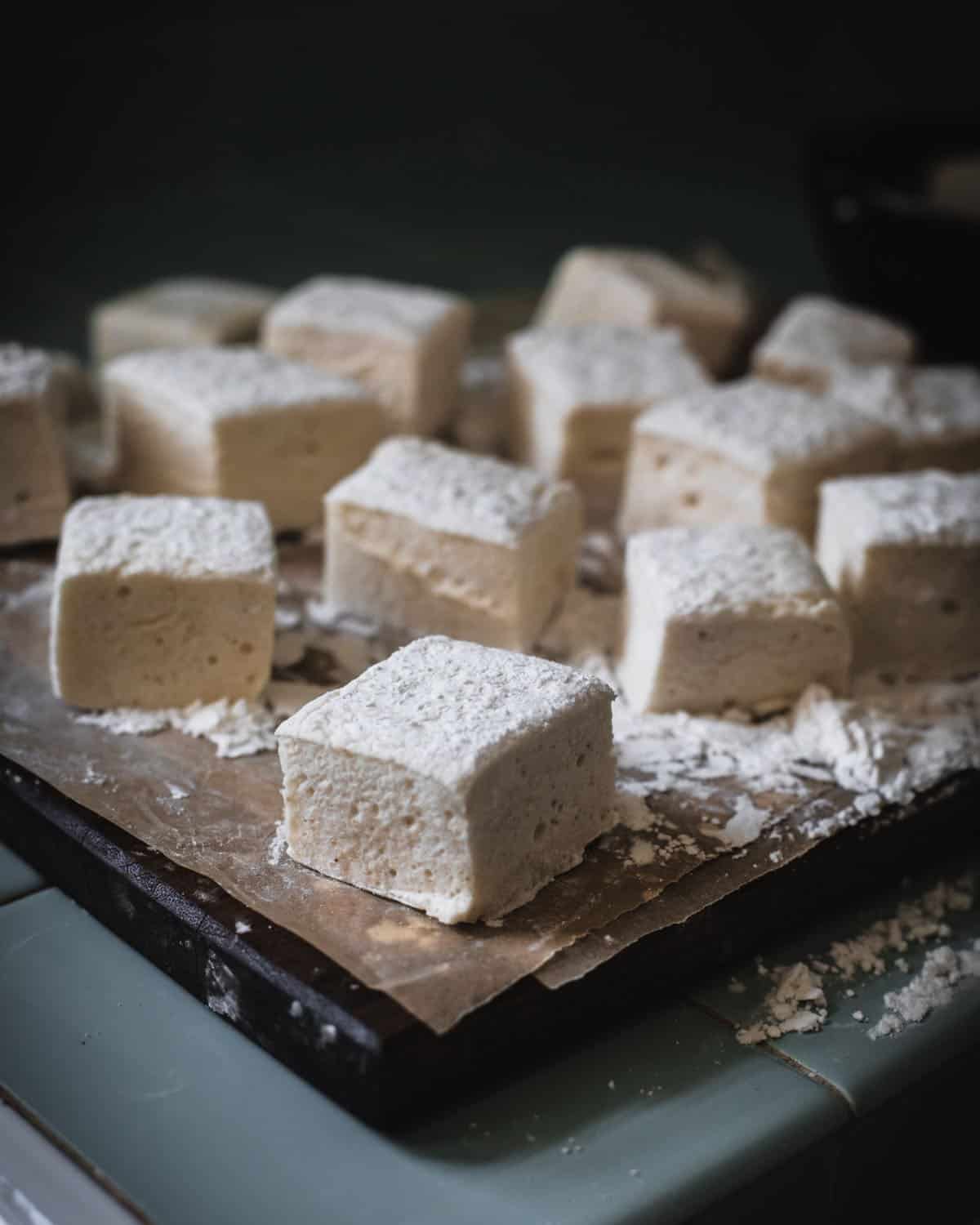 Cut marshmallow cubes on a wooden cutting board. 