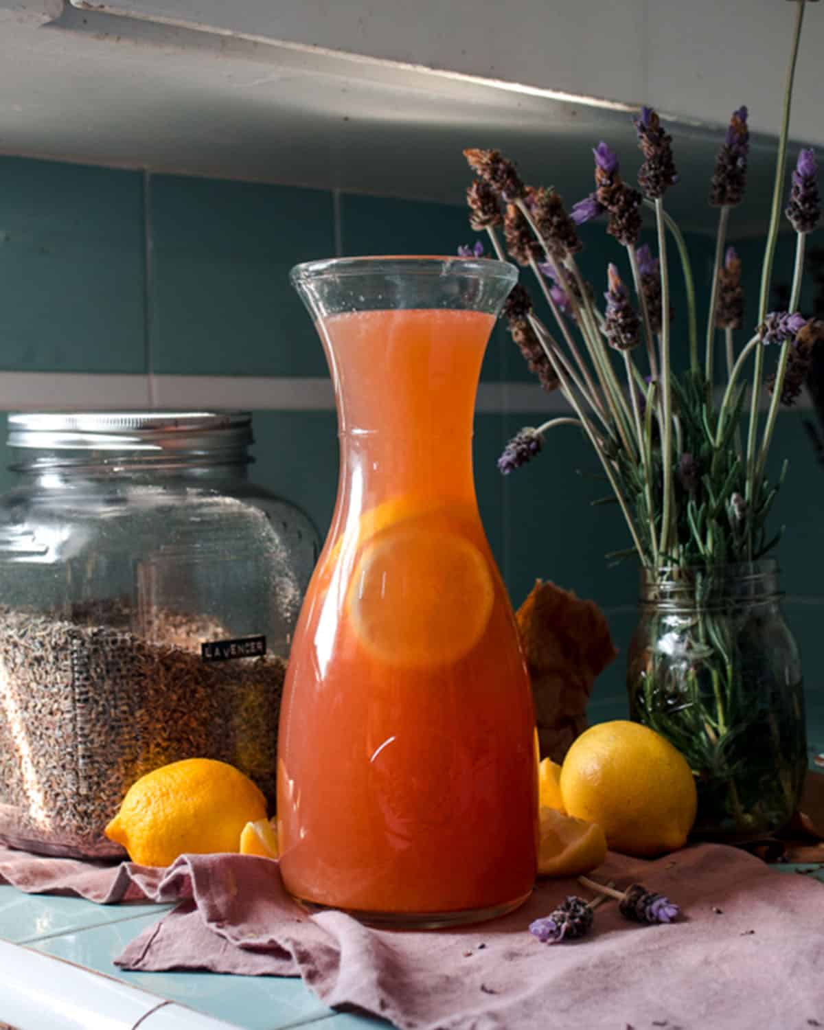 a glass carafe of lavender lemonade on a countertop