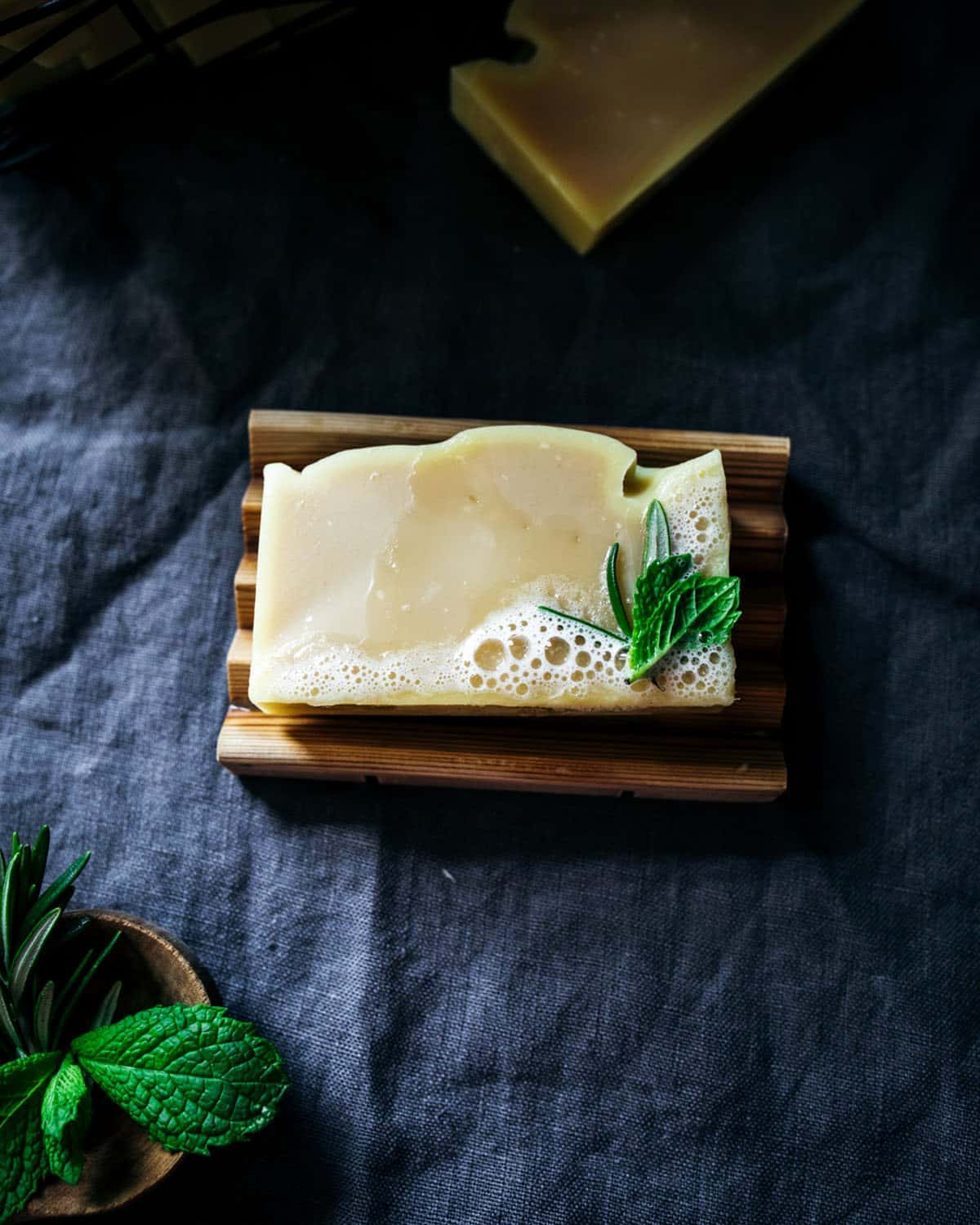 a shampoo bar with bubbles on a wooden soap dish