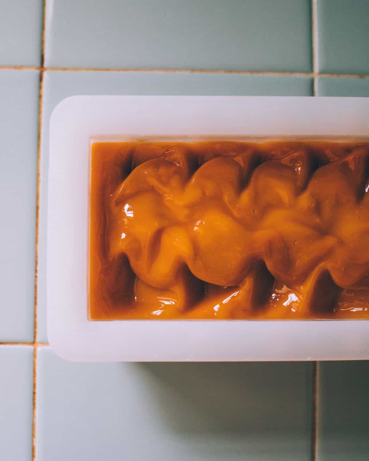 shampoo bar batter in a mold with a design on top