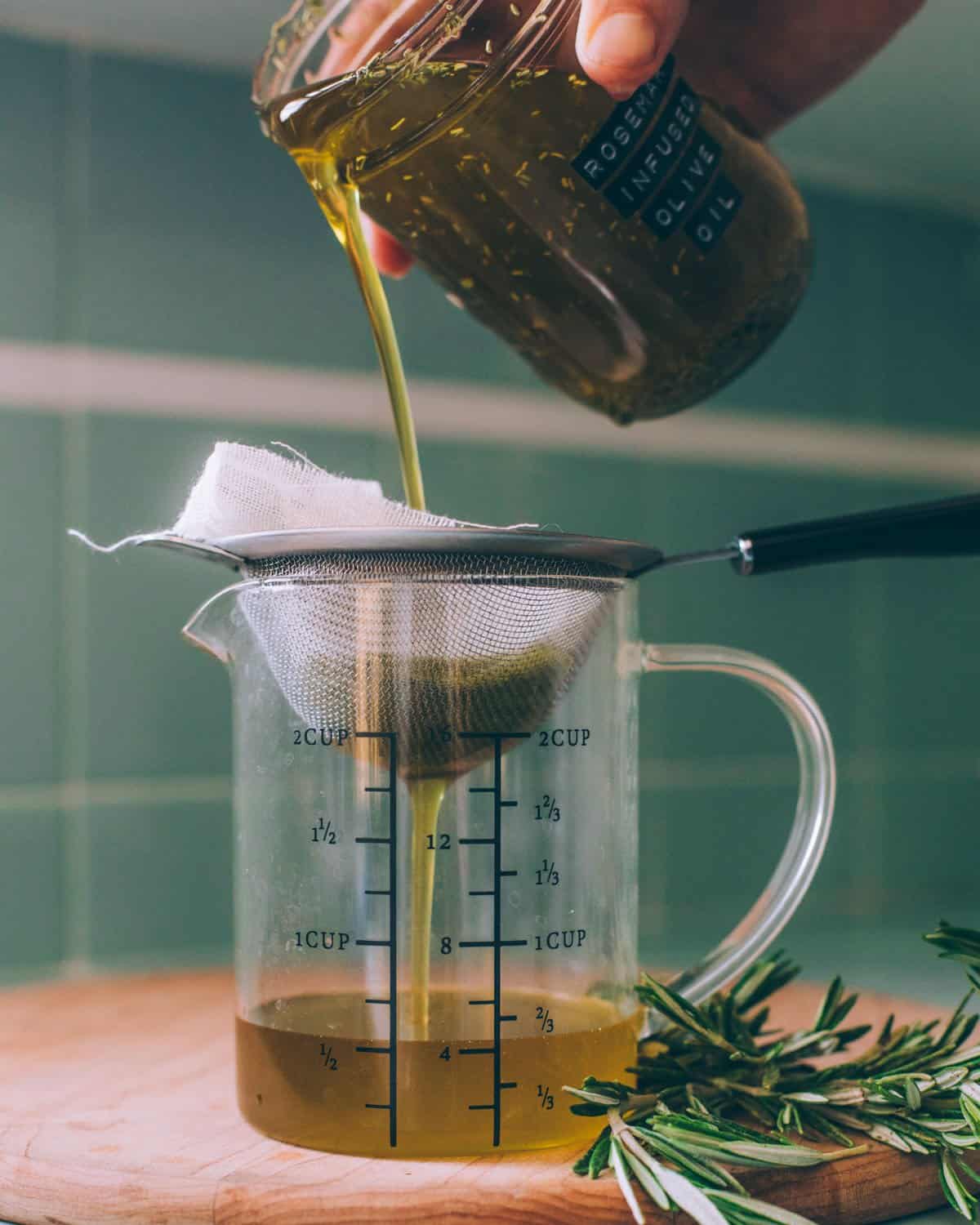 straining the rosemary infused oil