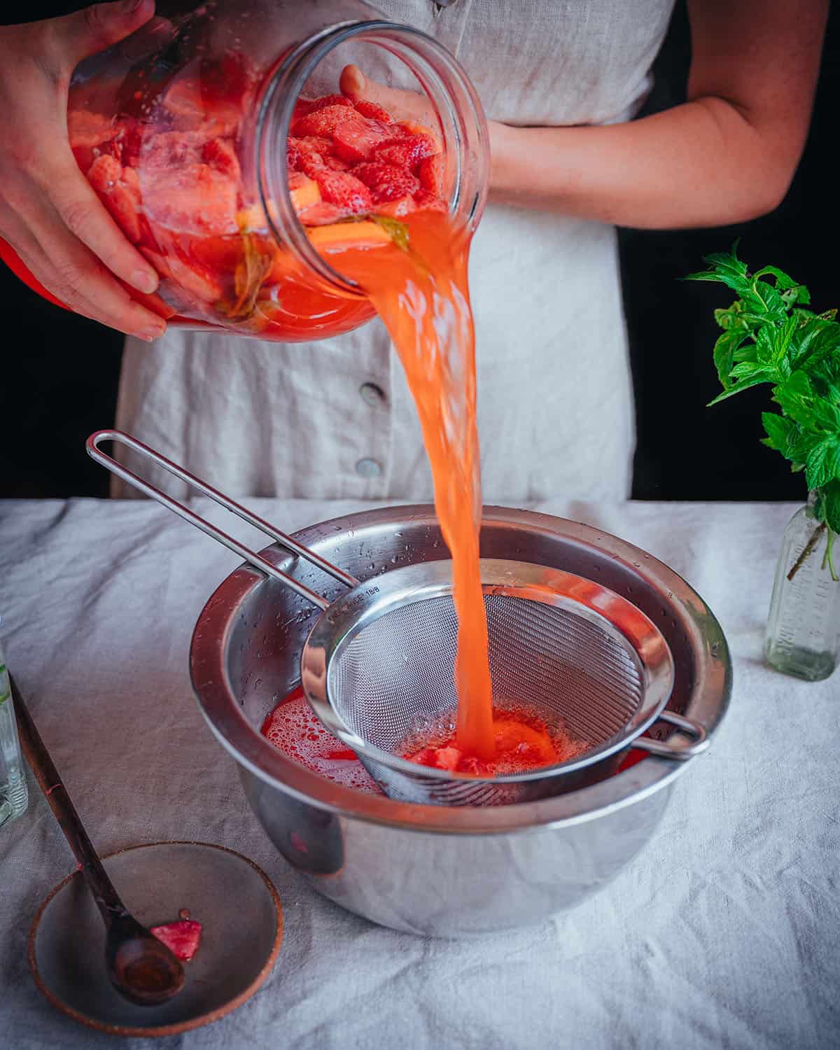 Straining yarrow soda into a bowl. 