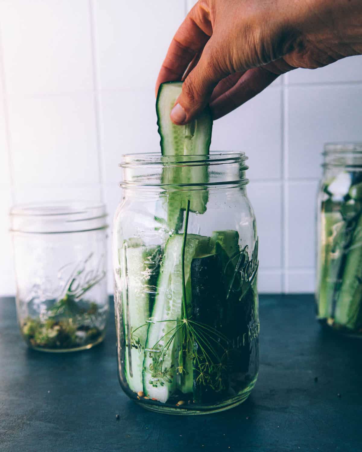 Cucumber spears being added to pickling jars. 