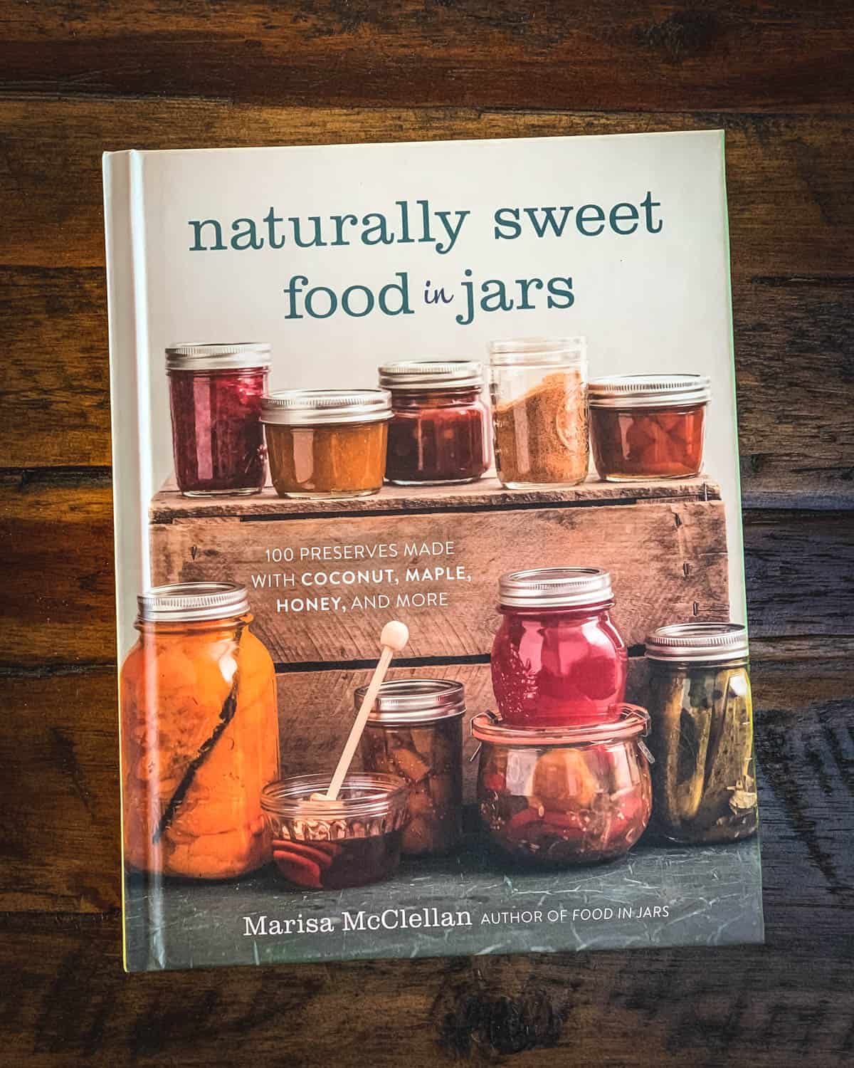 The book Naturally Sweet Food in Jars on a wooden table