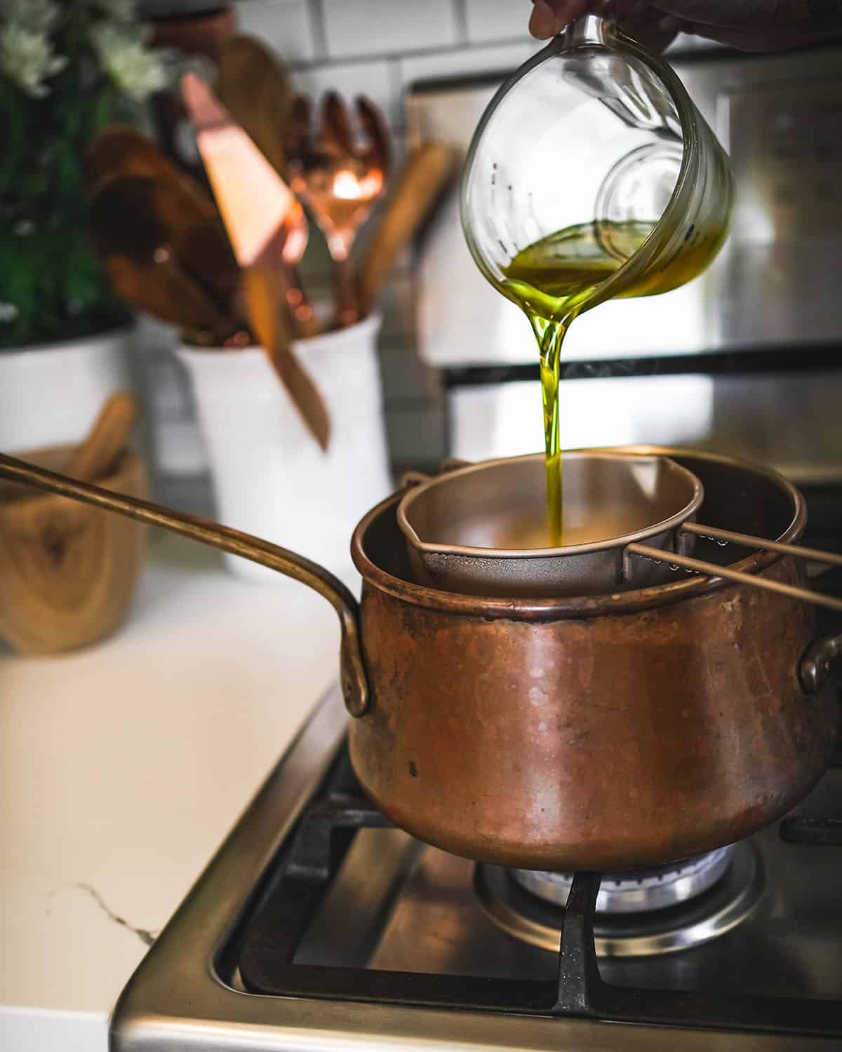 Lavender infused oil pouring into the double boiler with the beeswax.