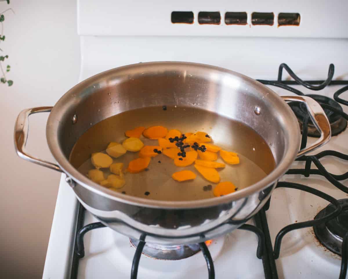 Turmeric and spices boiling in a pot.