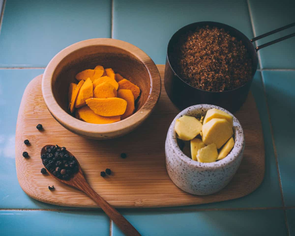 Sliced turmeric, ginger, and other ingredients in small bowls. 