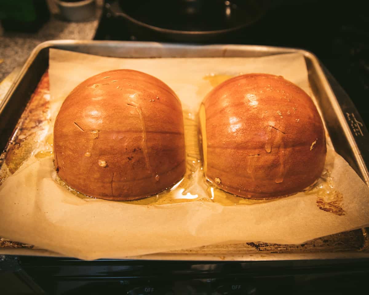 Roasted pumpkin halves cooling on a pan. 