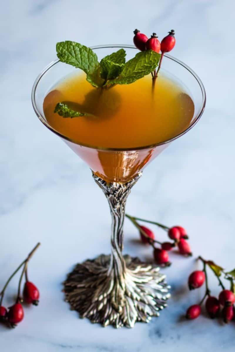 rose hip whiskey smash in a martini glass