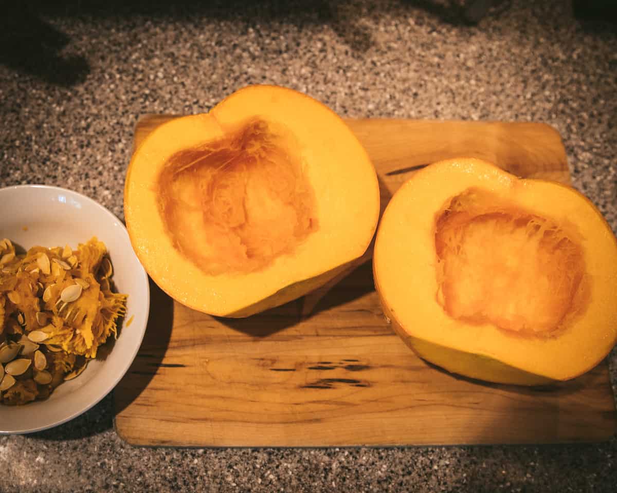 A pumpkin cut in half with seeds scooped out. 