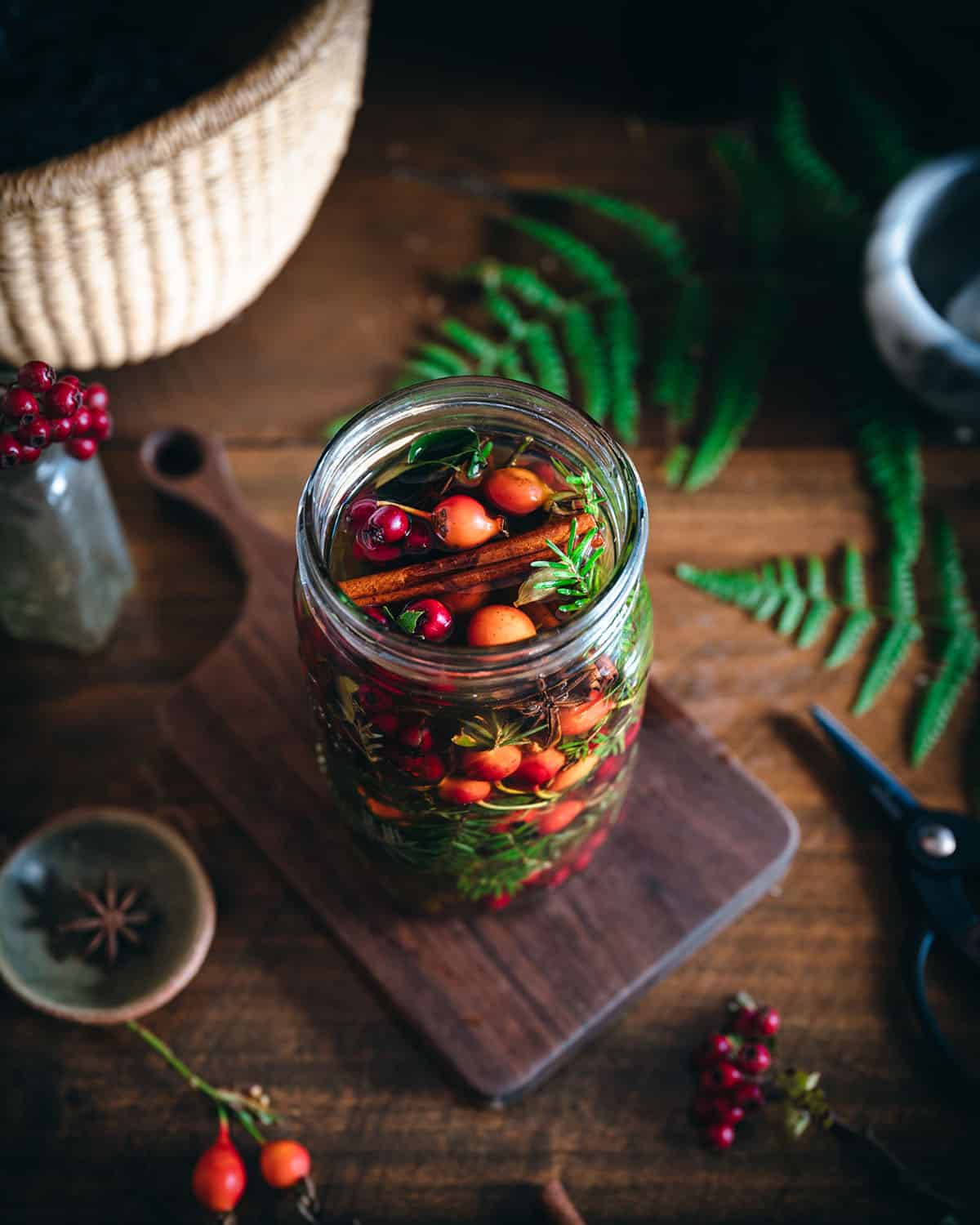 Top view of foraged plants and vinegar infusing in a jar. 