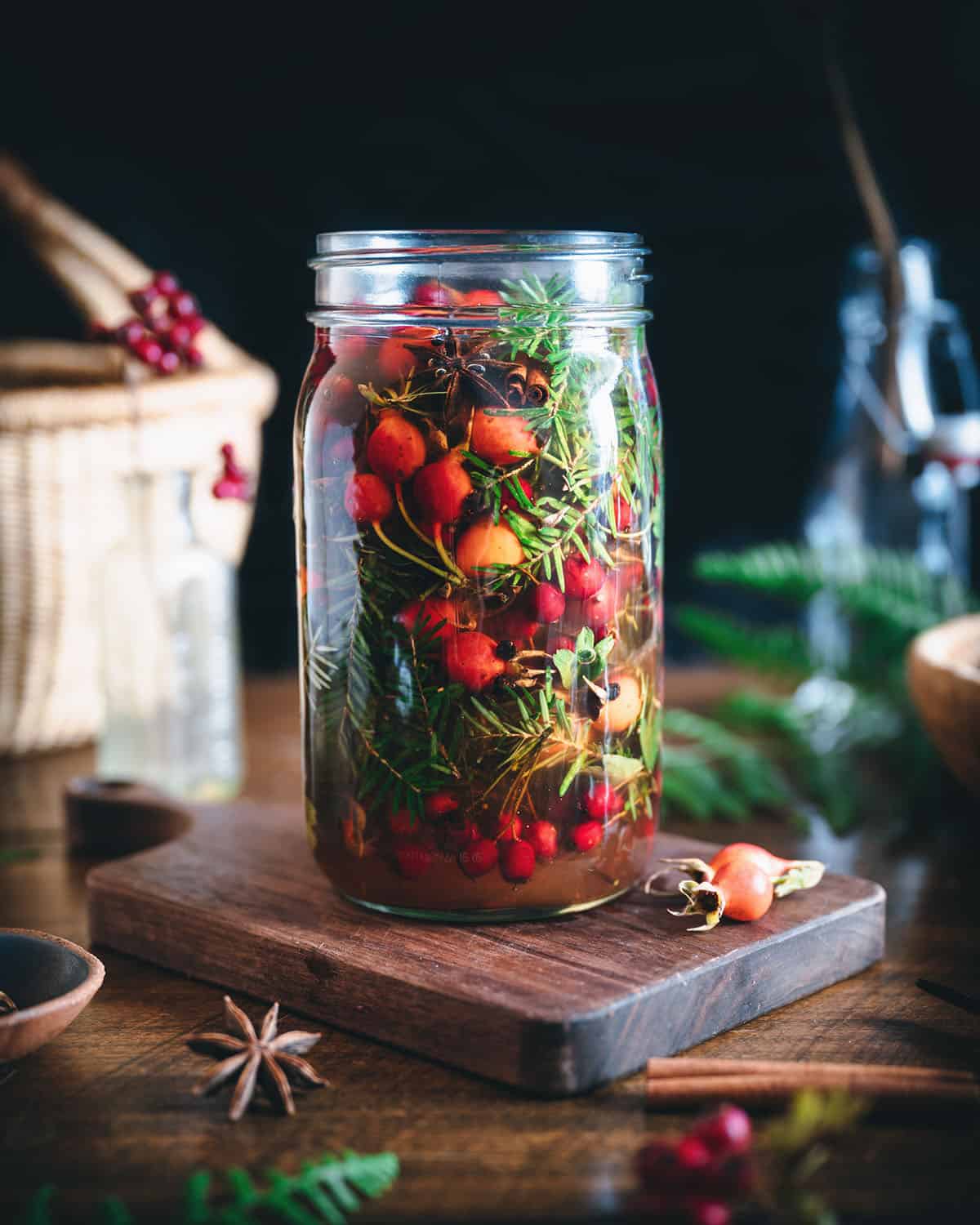 Mountain infused vinegar in a jar, with foraged ingredients still infusing the vinegar. 