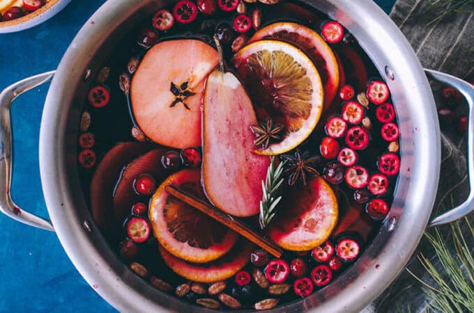 Mulled wine in a pot with garnishes, top view.