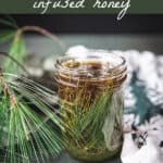 A jar of infusing honey with pine needles, surrounded by fresh pine fronds with a top banner that reads pine needle infused honey.