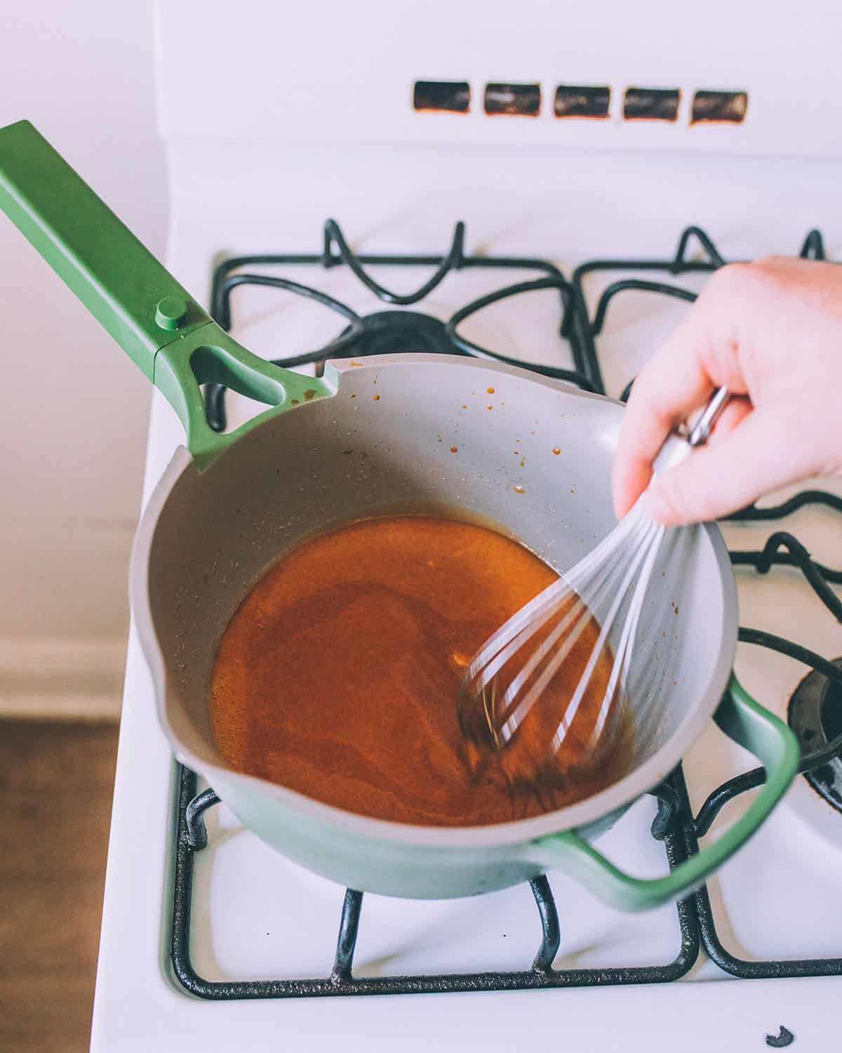 A pot whisking liquid gelatin with the rosehip powders. 