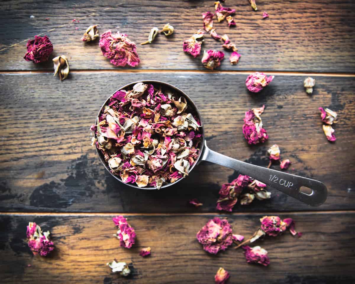 Dried rose petals in a measuring cup.