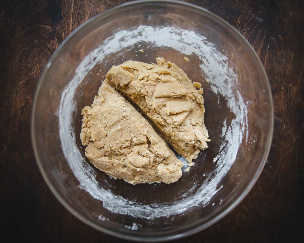 Dough in a clear bowl, cut in half. 