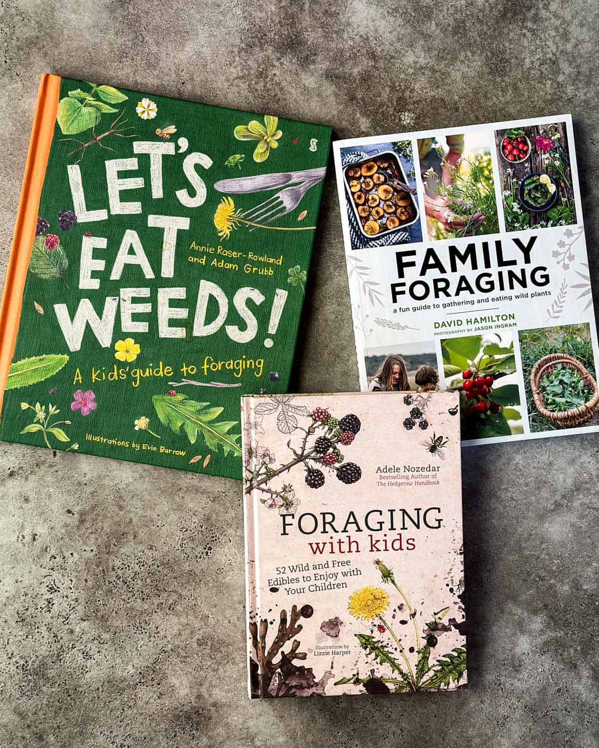3 kids foraging books face up on a gray surface.