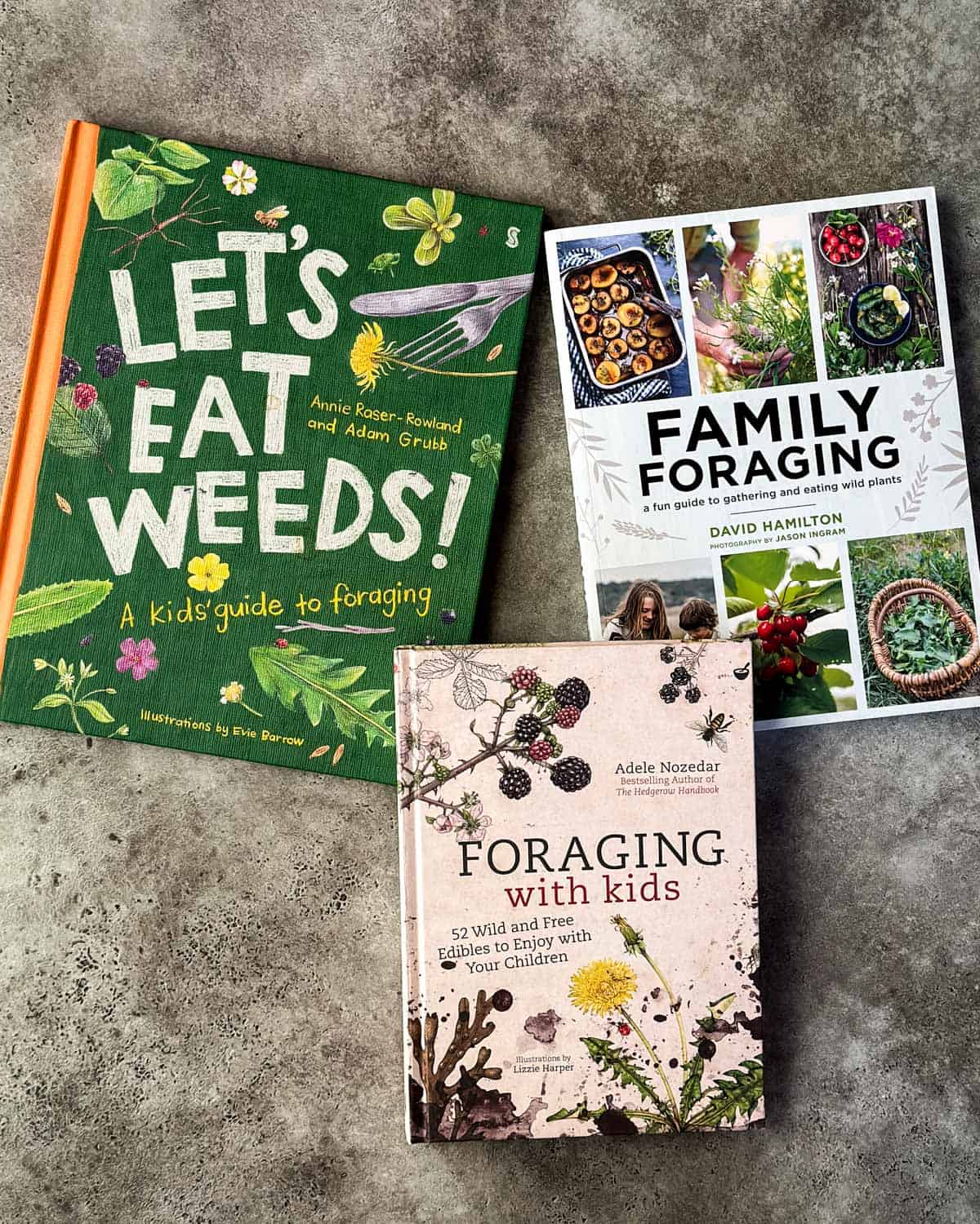 3 kids foraging books face up on a gray surface. 