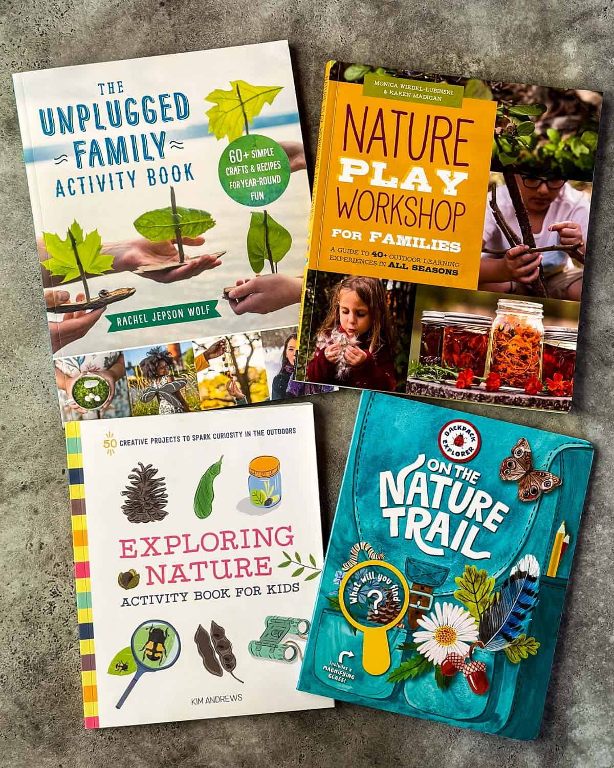4 nature books for kids face up on a gray surface. 