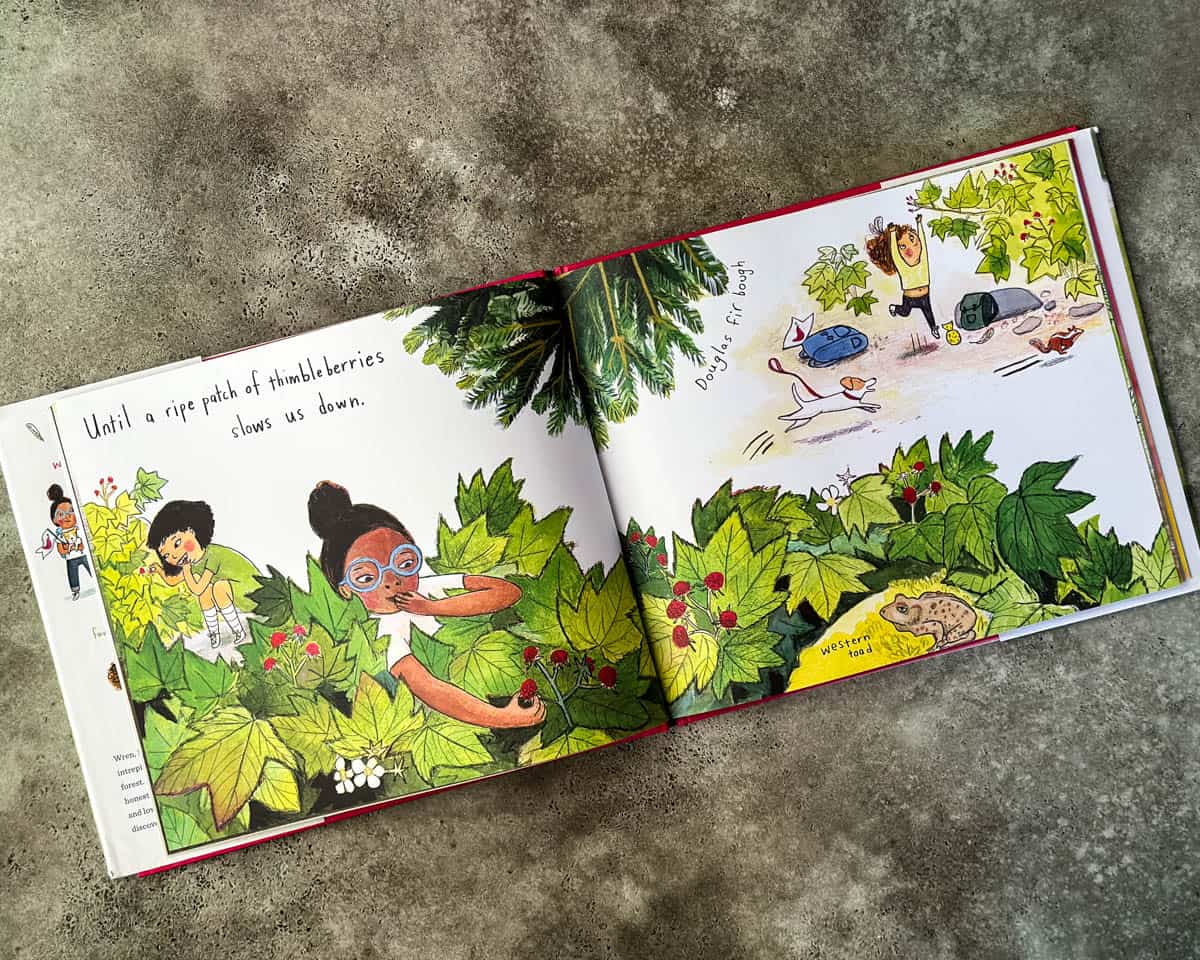 An open 2 page view of the book The Hike with illustrations of kids foraging berries. 