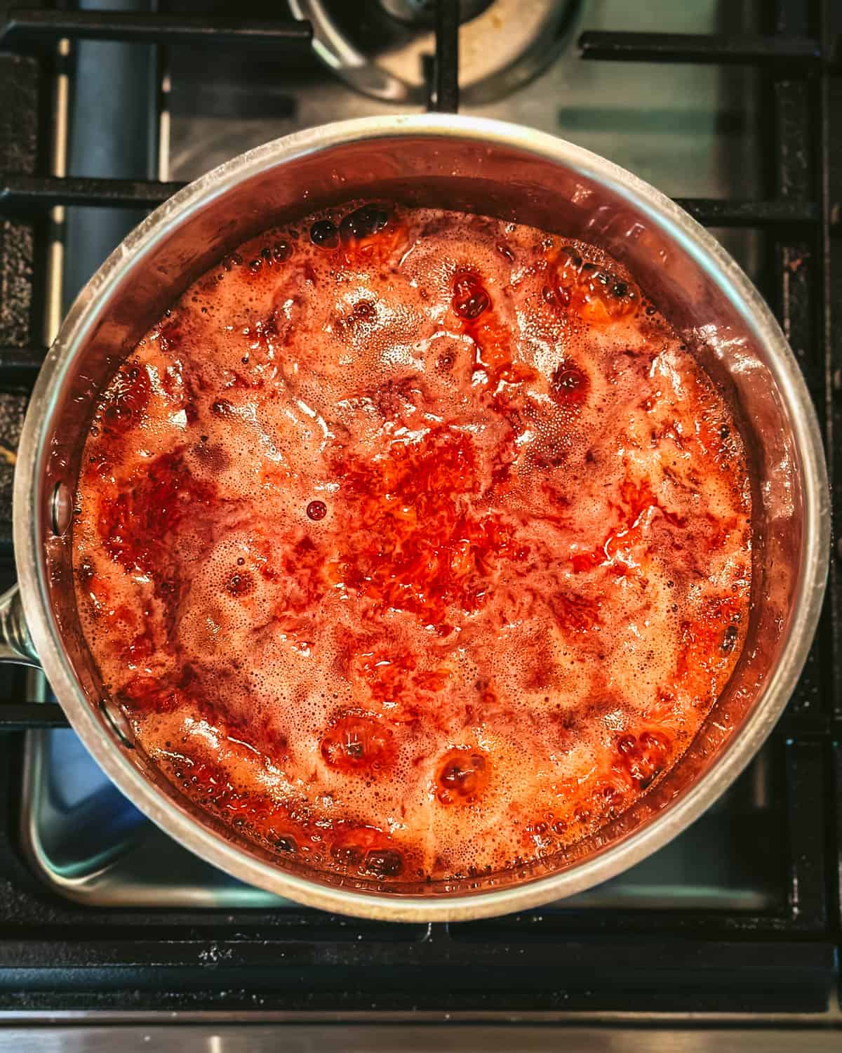 Strawberries boiling in a pot on the stove. 