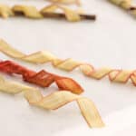 Candied rhubarb ribbons, some are light colored with pink along the edges, and some are dark pink.