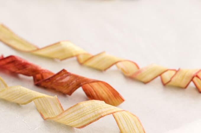 Candied rhubarb ribbons, some are light colored with pink along the edges, and some are dark pink.