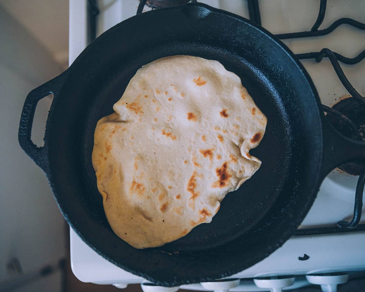 A flipped tortilla in a cast iron pan. 