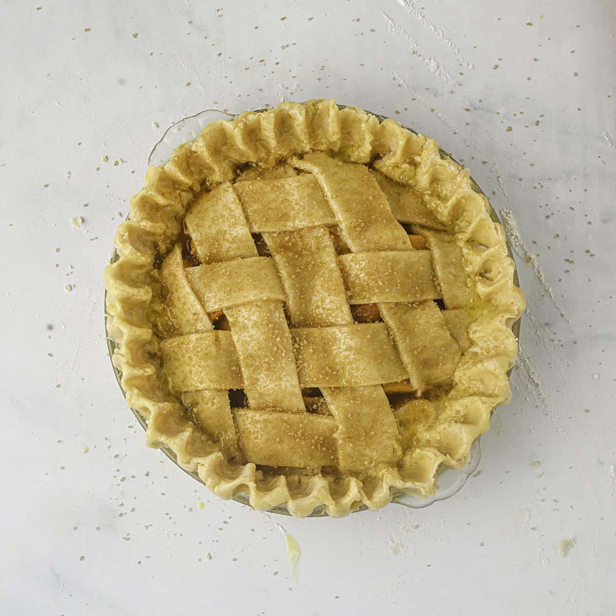 A fresh peach pie with a lattice crust top ready to bake, top view. 