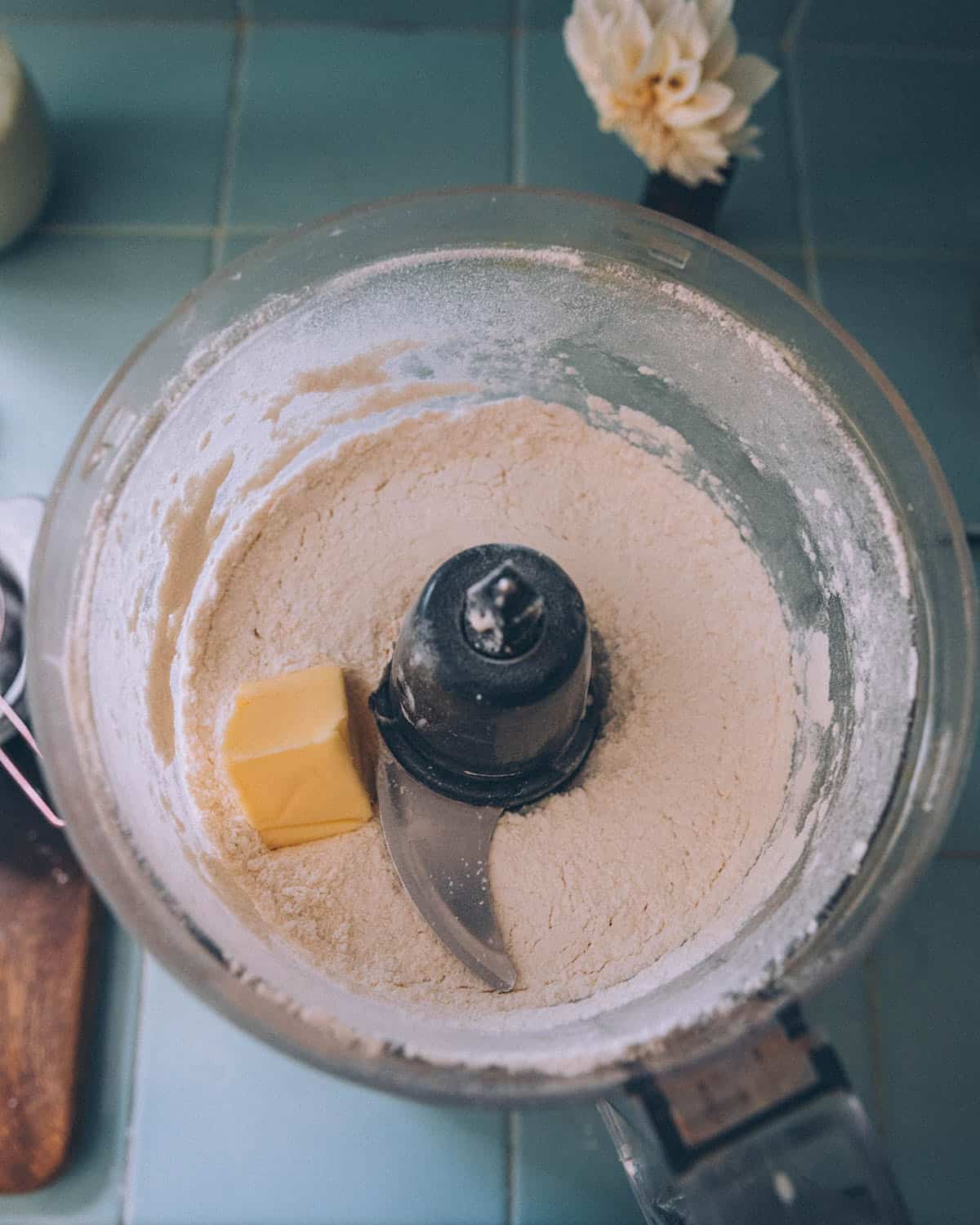 A food processor with flour and butter, top view.