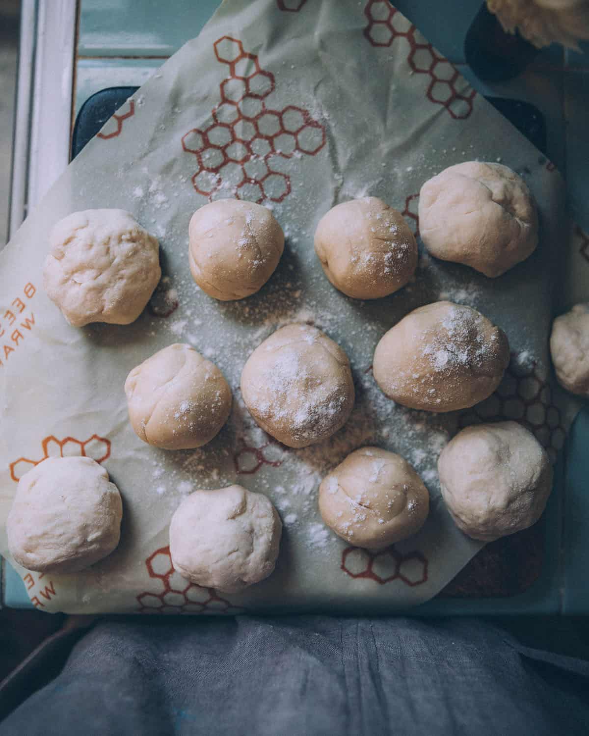 Balls of sourdough tortilla doughs on a beeswax surface, top view. 