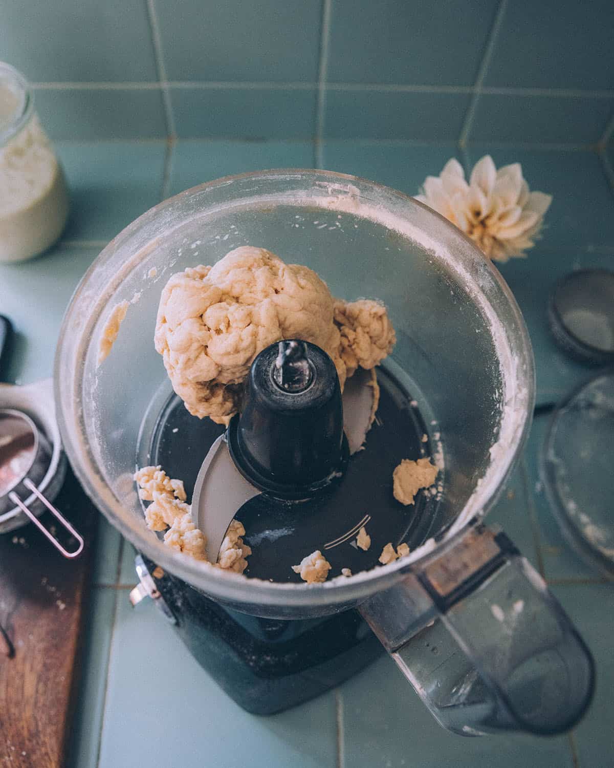 Top view of food processor with a ball of dough formed. 