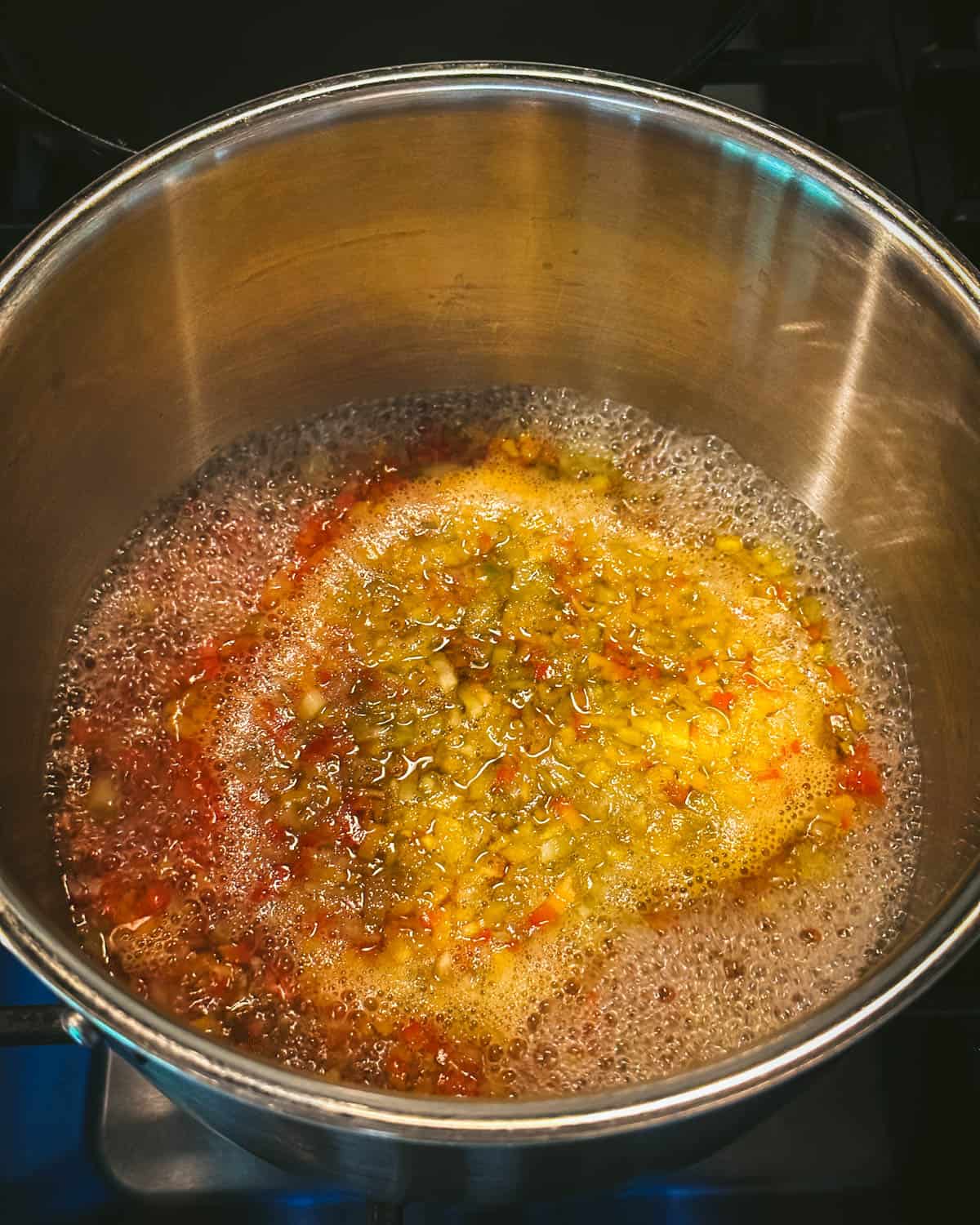 A saucepan with chopped peppers boiling in vinegar, top view. 