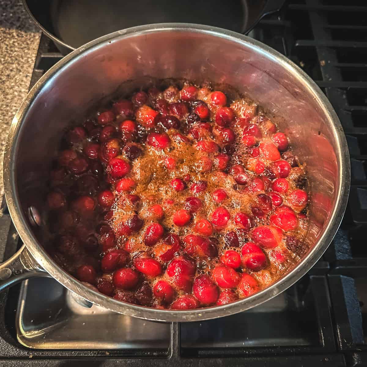 Cranberries and pickling ingredients starting to boil in a pot. 