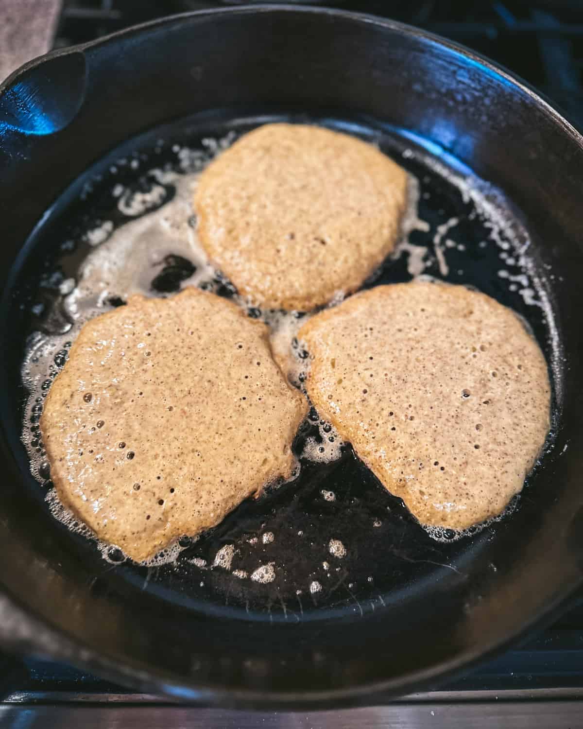 Acorn pancakes cooking showing bubbles in the batter ready to flip. 
