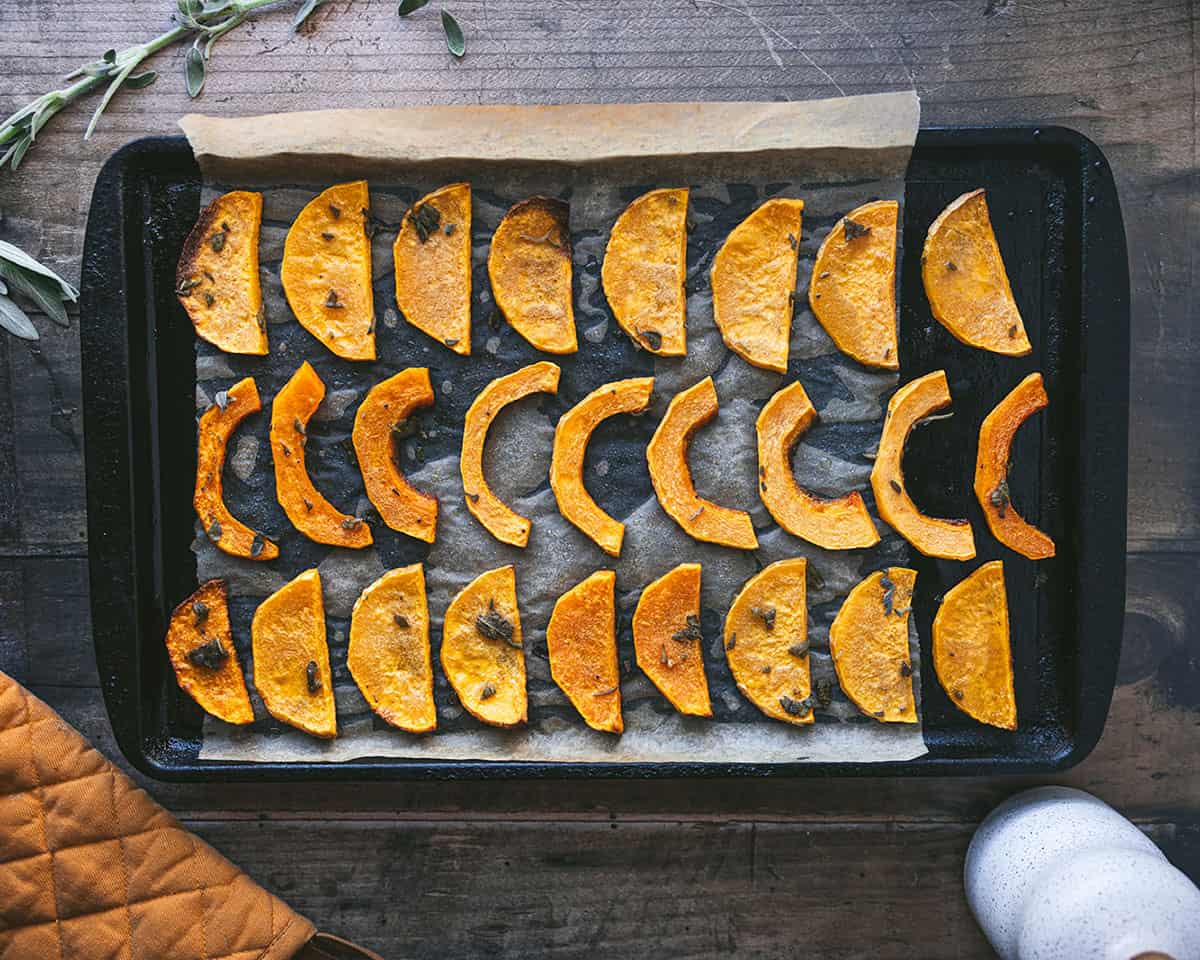 Roasted butternut squash slices on a baking sheet. 