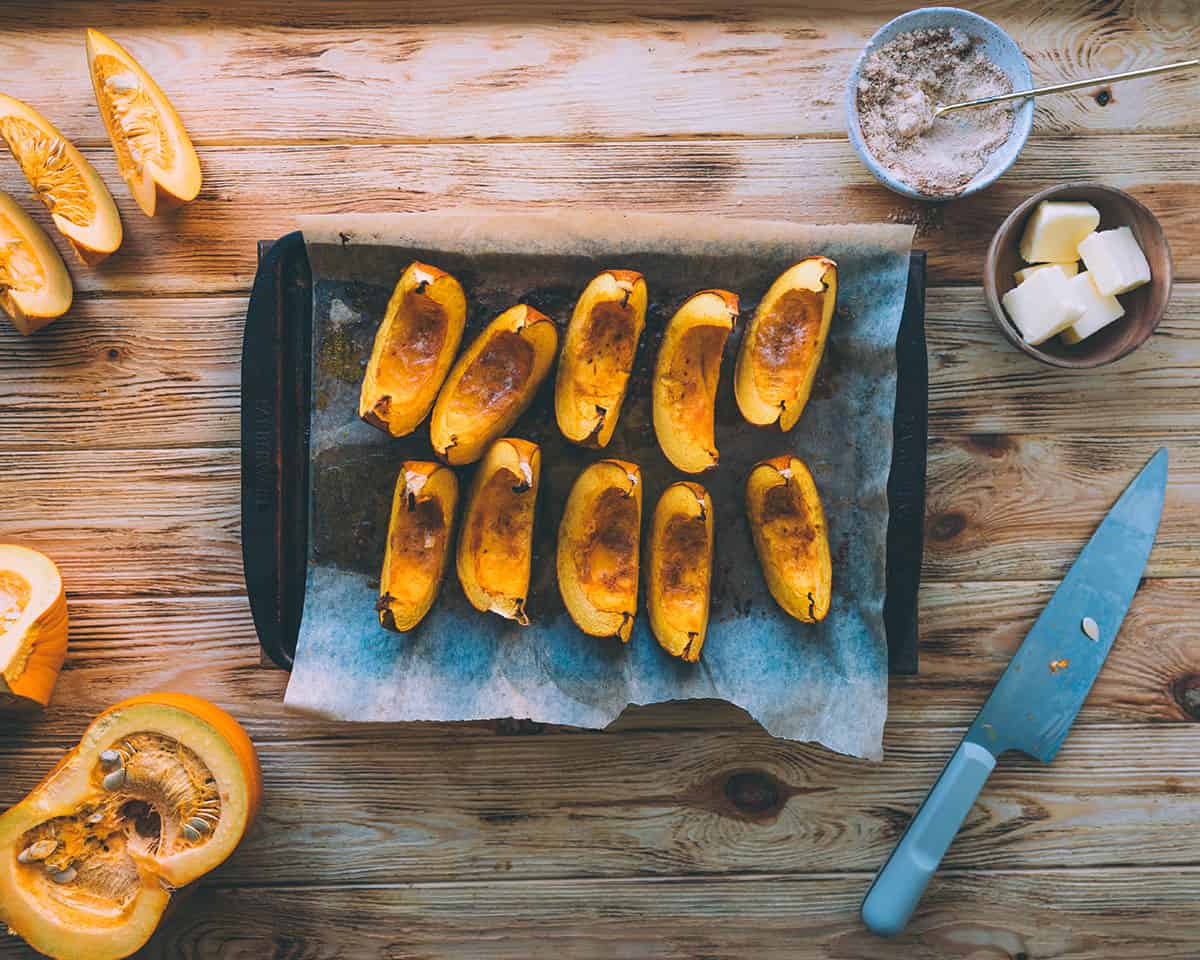 Pumpkin wedges on a sheet pan, roasted golden brown at the edges. 